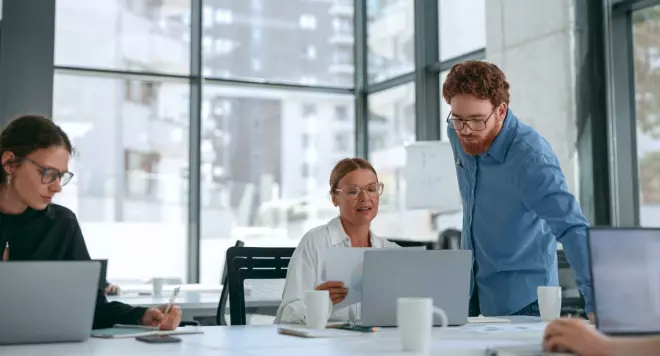 Kobieta rozmawiająca z pracownikiem przy biurku